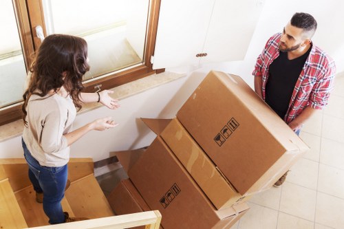 Packers wrapping fragile household items for flat removals in Camden